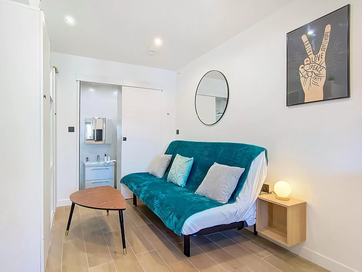 canape salle de bain apparente location appartement argenteuil Salon moderne et épuré avec canapé et miroir.