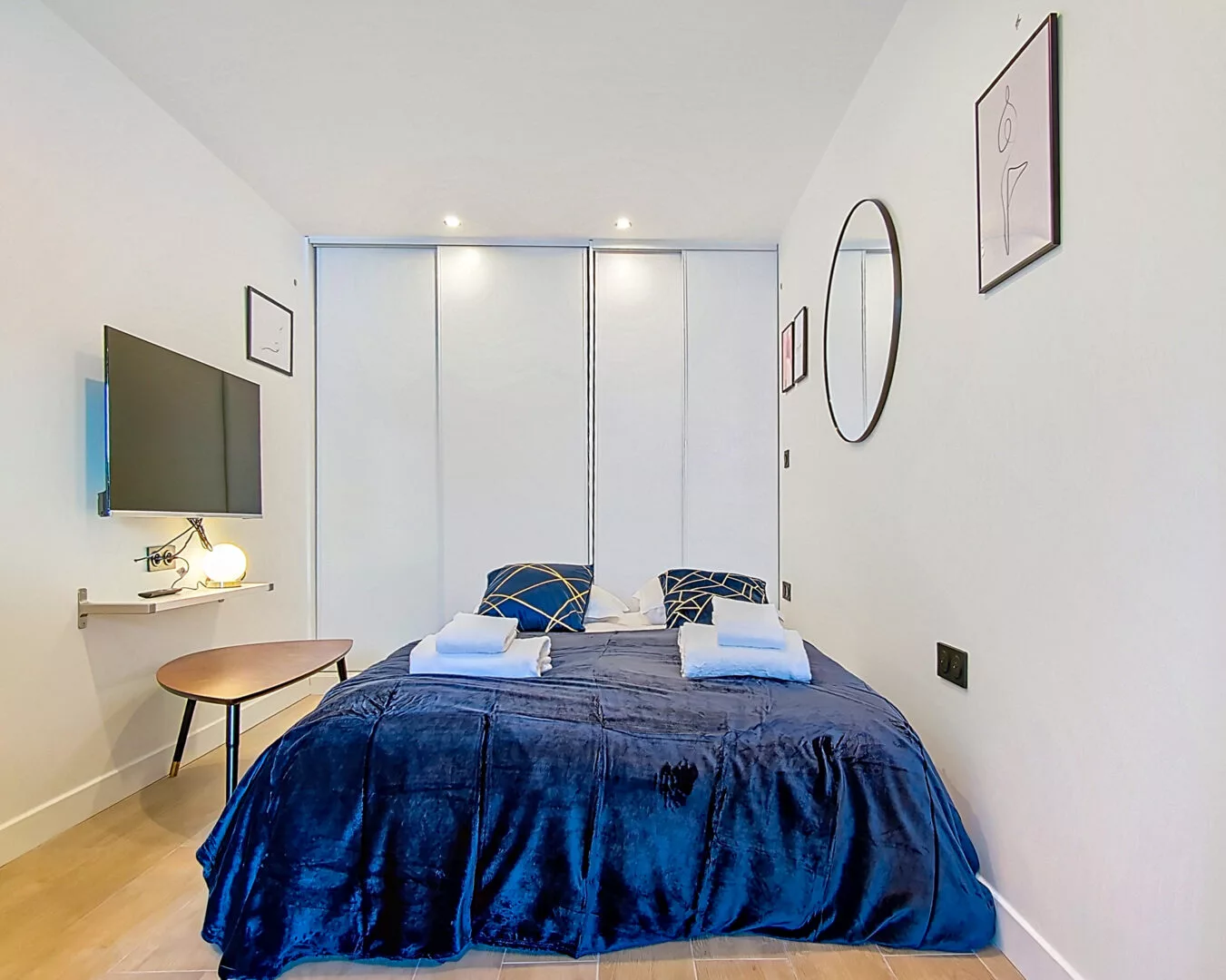 chambre moderne avec lit double et télévision murale location appartement argenteuil Chambre moderne avec lit et décoration minimaliste.