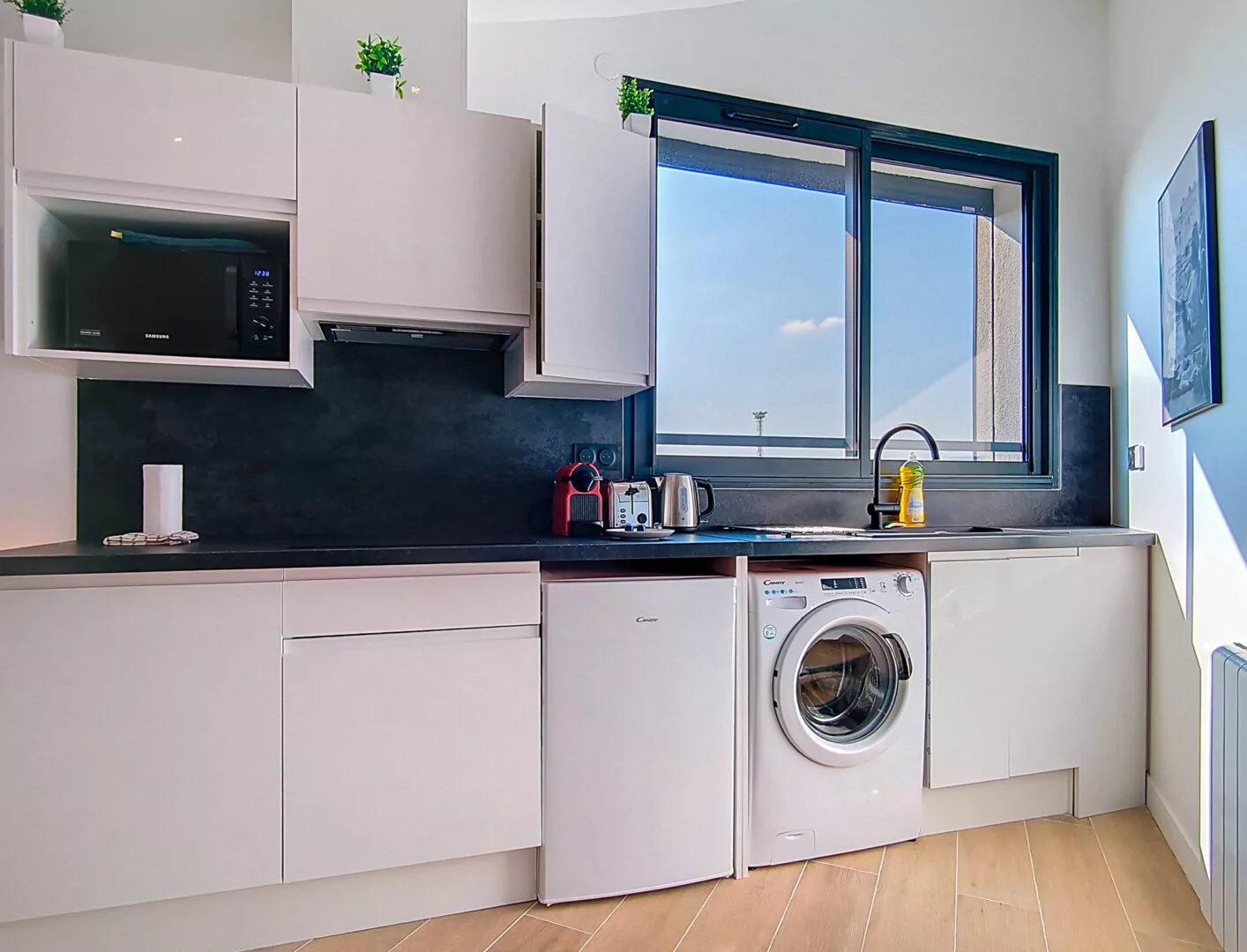 cuisine moderne lumineuse location appartement court et long sejour argenteuil Cuisine moderne avec fenêtres et lave-linge.