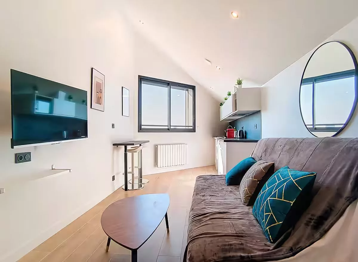 salle de bain moderne location appartement court et long sejour argenteuil Salon moderne avec canapé et télévision murale.