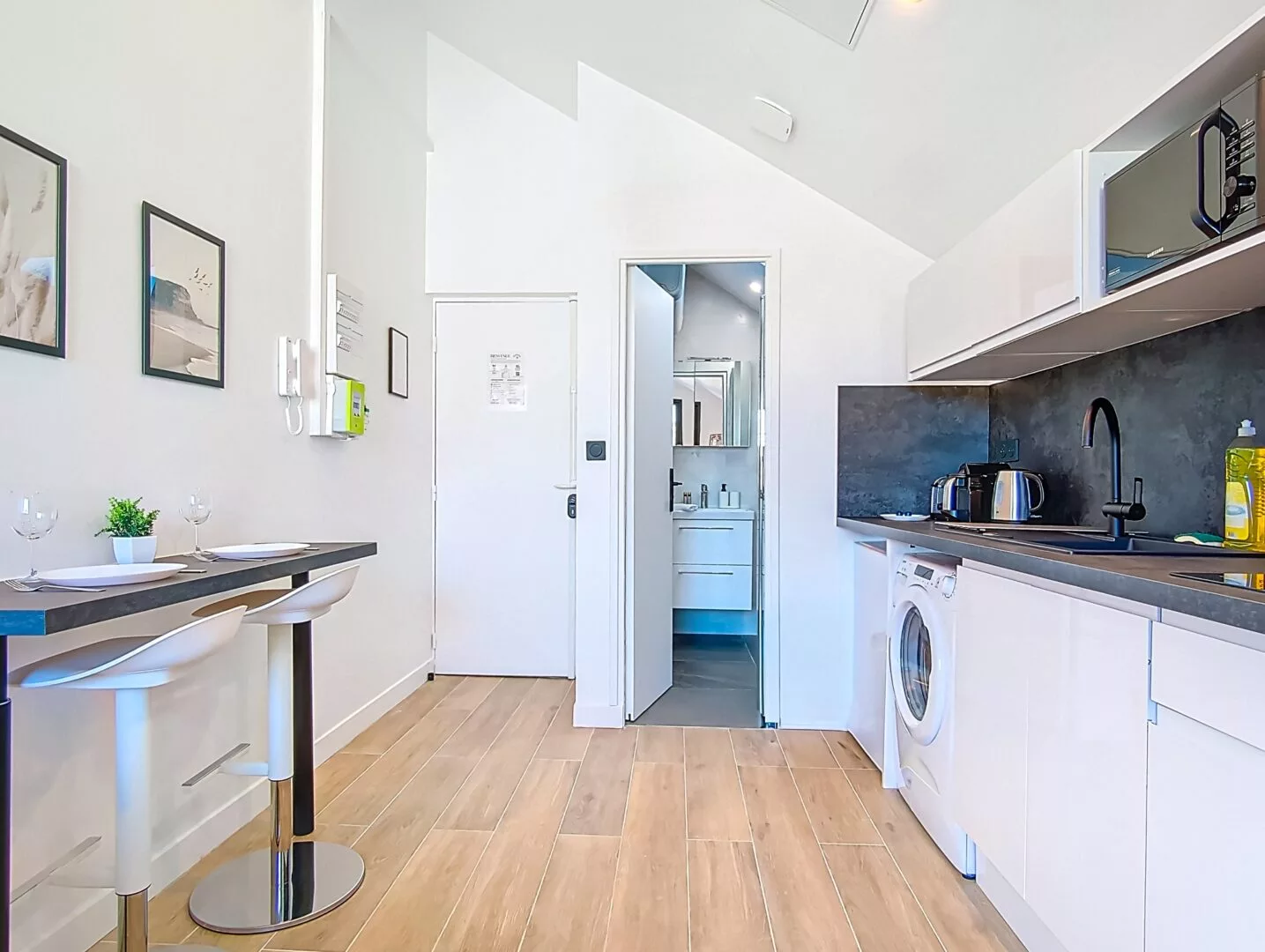 vue generale cuisine salle de bain location appartement court et long sejour argenteuil Cuisine moderne avec bar et équipement complet.