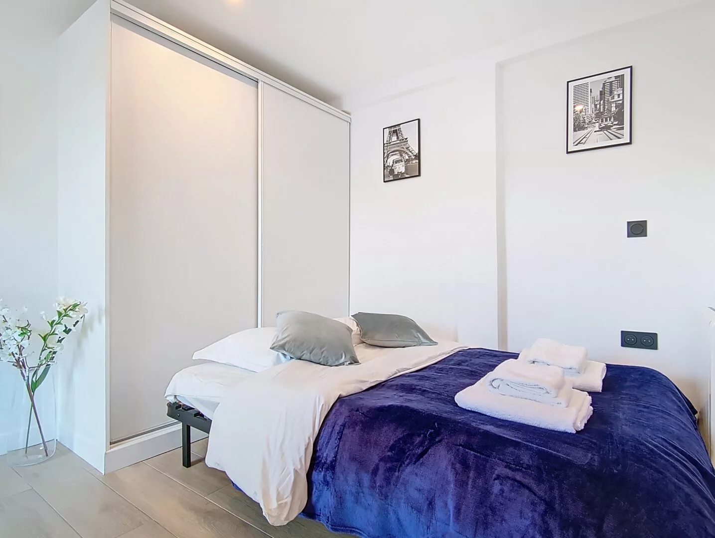 canapé lit location studio voyage argenteuil Chambre moderne avec lit et décor minimaliste.