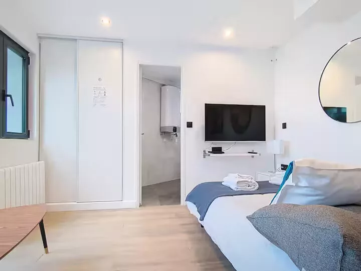 lit be happy argentueil Chambre moderne avec lit double et télévision.