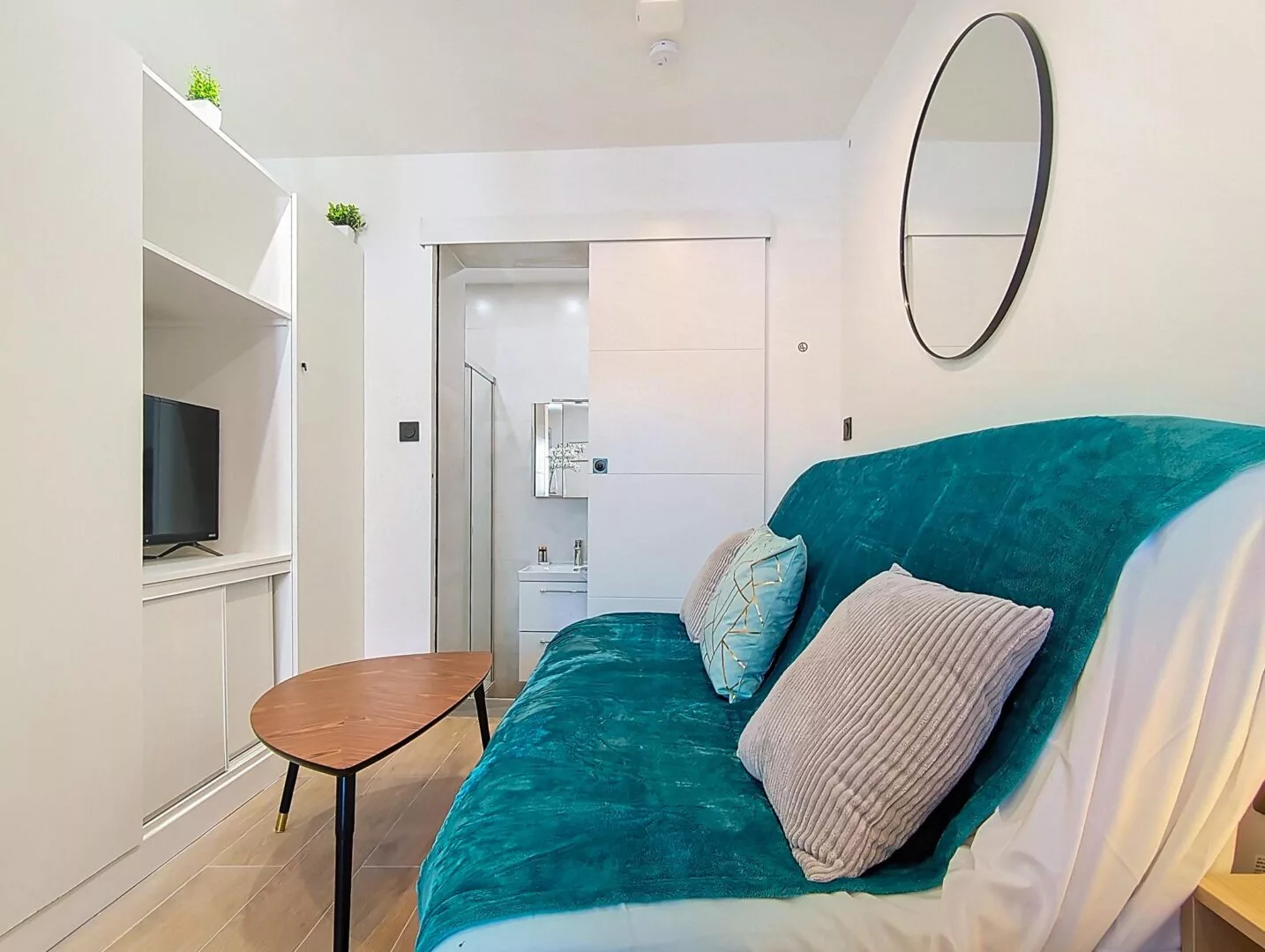 canape turquoise salle de bain location appartement argenteuil Salon moderne avec canapé turquoise et miroir rond.