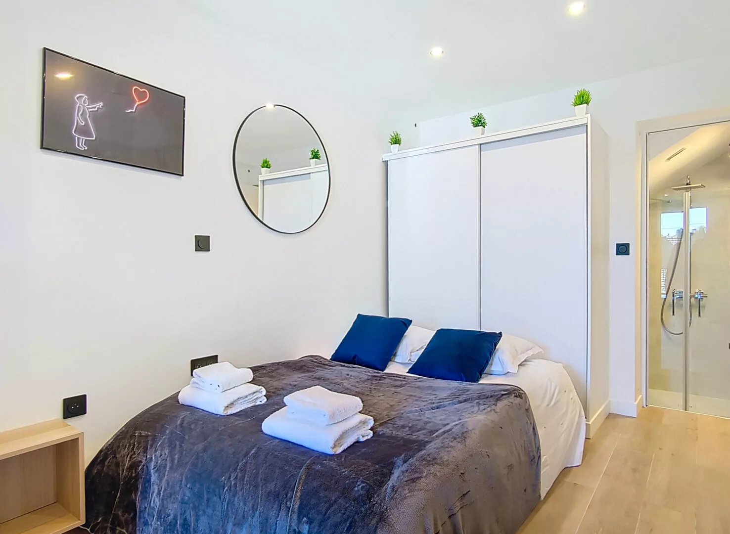 chambre avec salle de bain location appartement argenteuil Chambre moderne avec lit et miroir.