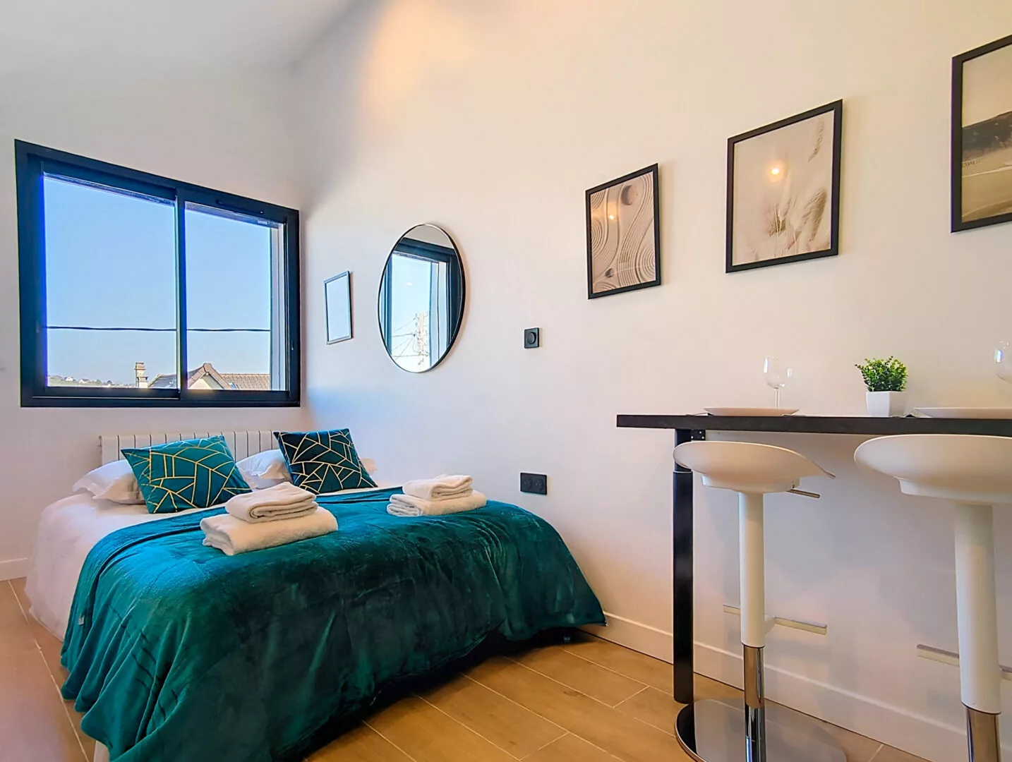 chambre confortable lumineuse location appartement court et long sejour argenteuil Chambre moderne avec lit double, lumières et table haute.