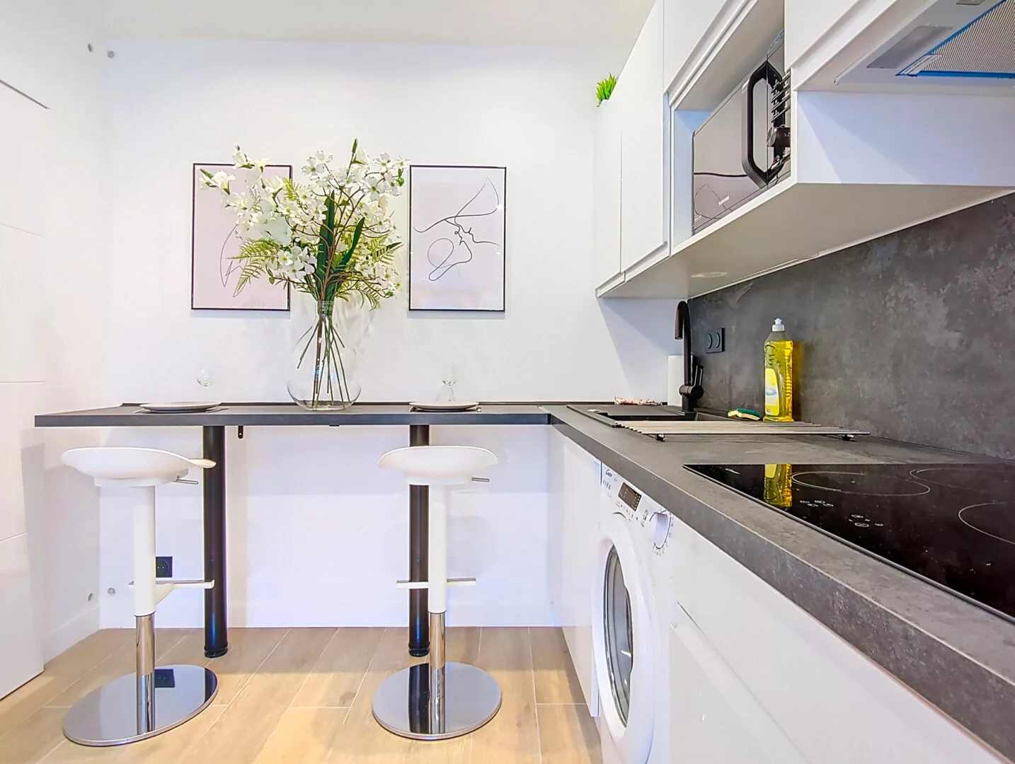 cuisine moderne avec bar et tabourets location appartement argenteuil Cuisine moderne avec tabourets et fleurs.