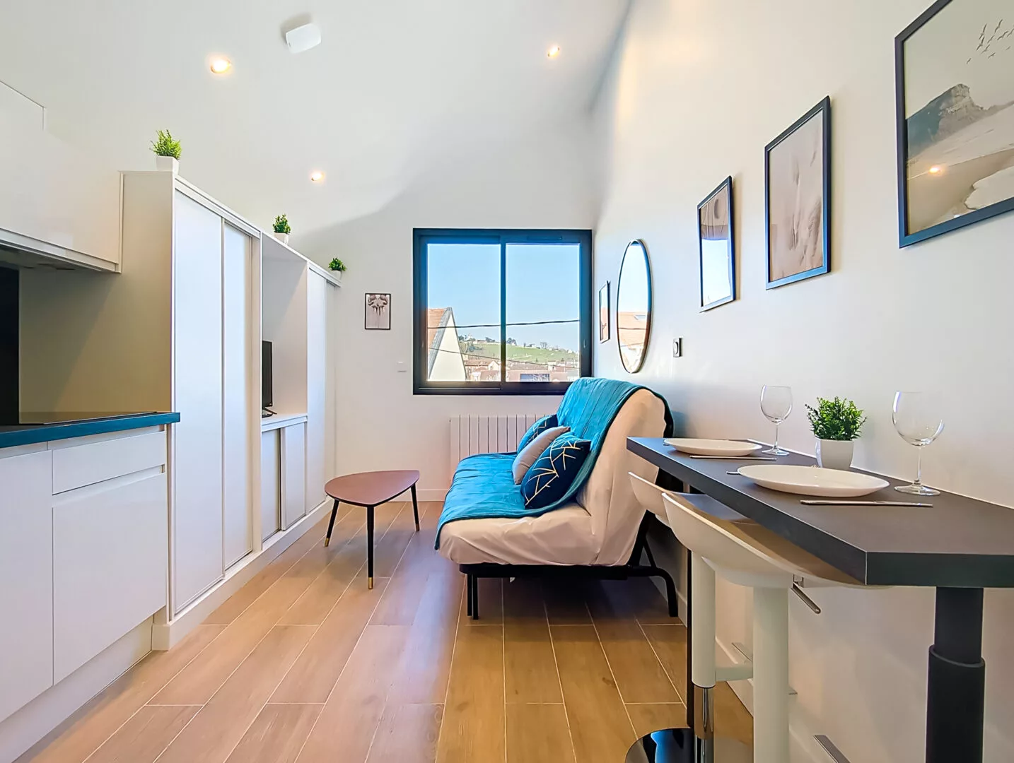 salon et coin repas lumineux location appartement court et long sejour argenteuil Petit salon moderne avec canapé et table à manger.