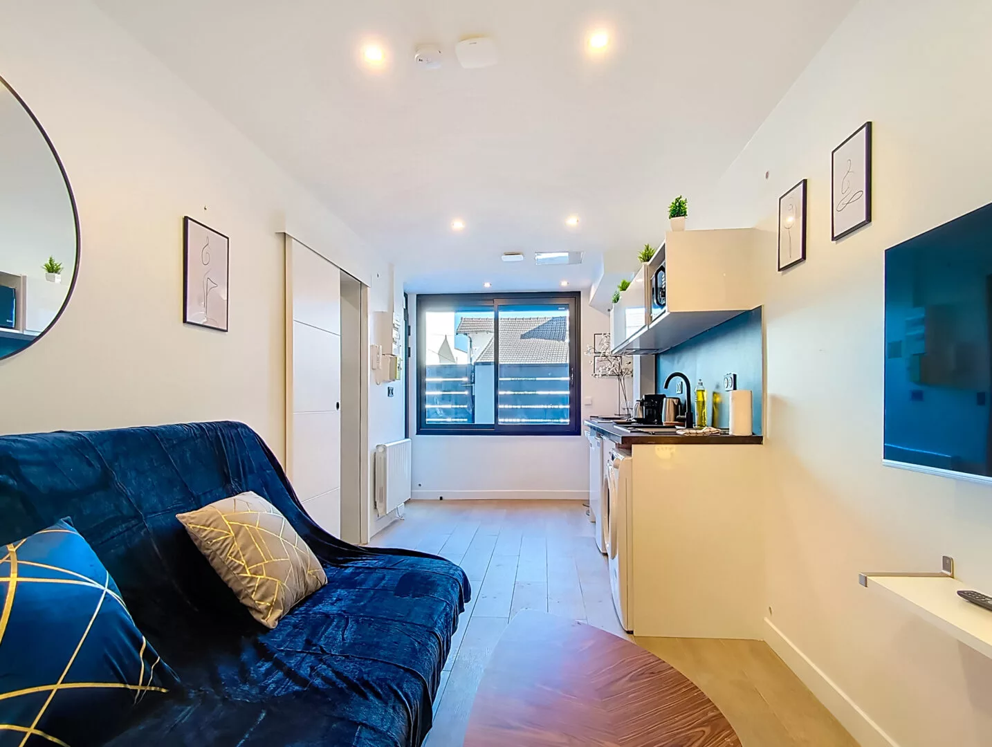 salon moderne avec cuisine ouverte et canapé bleu location appartement argenteuil Appartement moderne avec salon et cuisine ouverte.