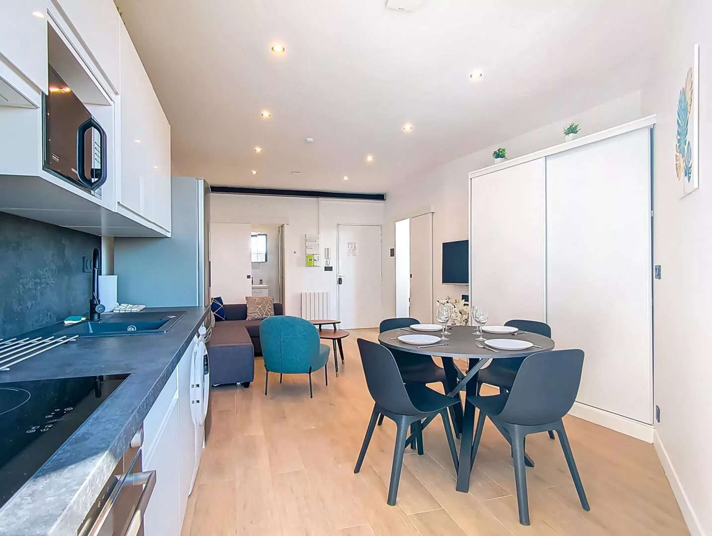 vue globale cuisine sejour location appartement court sejour argenteuil Cuisine-salon moderne avec coin repas circulaire.