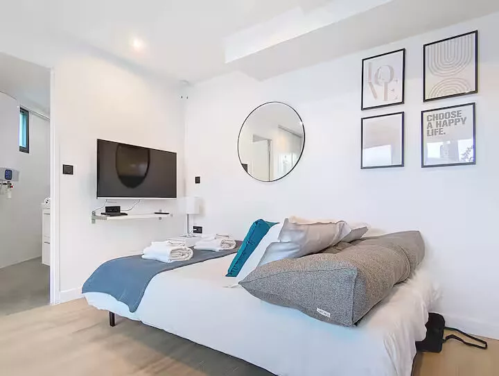 chambre vue be happy argentueil Chambre moderne avec lit, télé et décor minimaliste.