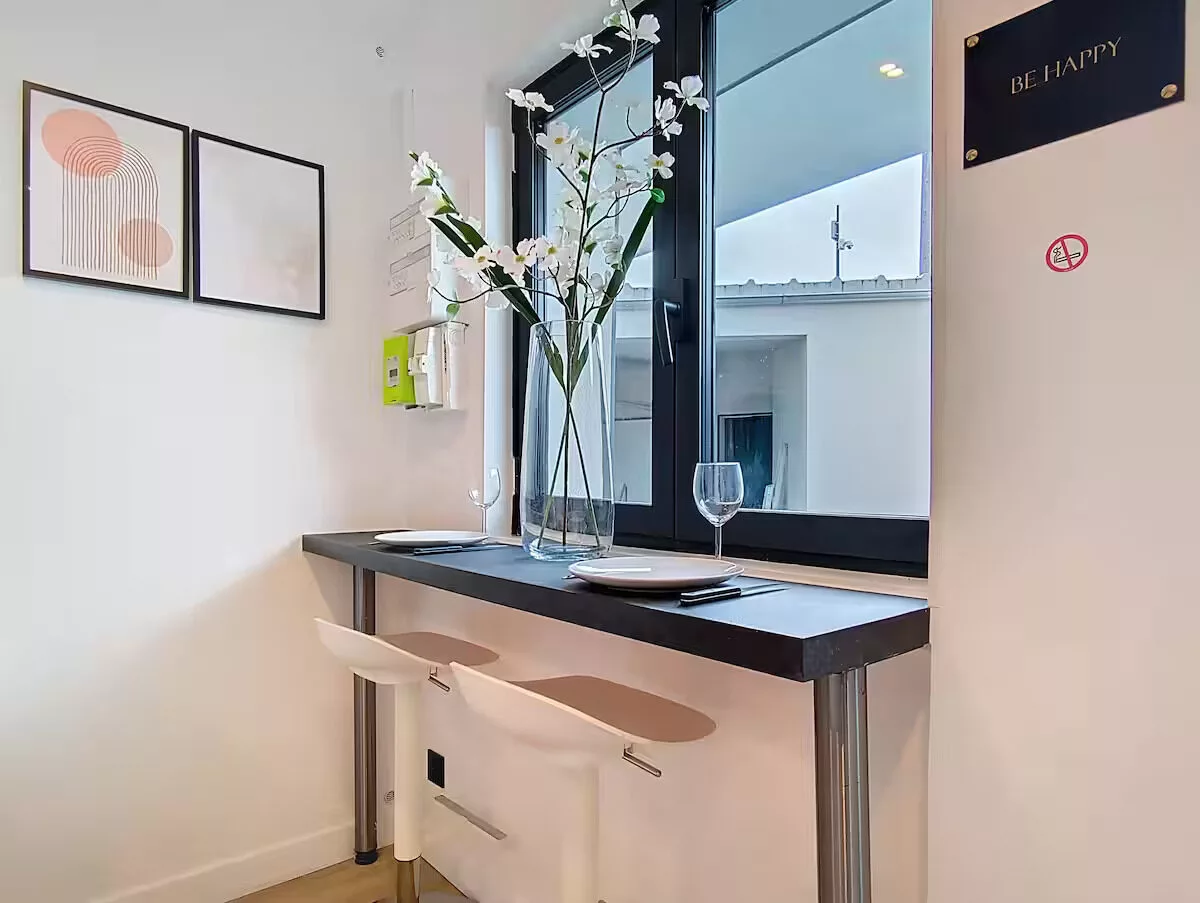 coin repas studio be happy argentueil Coin-repas minimaliste avec fenêtre et décorations murales.