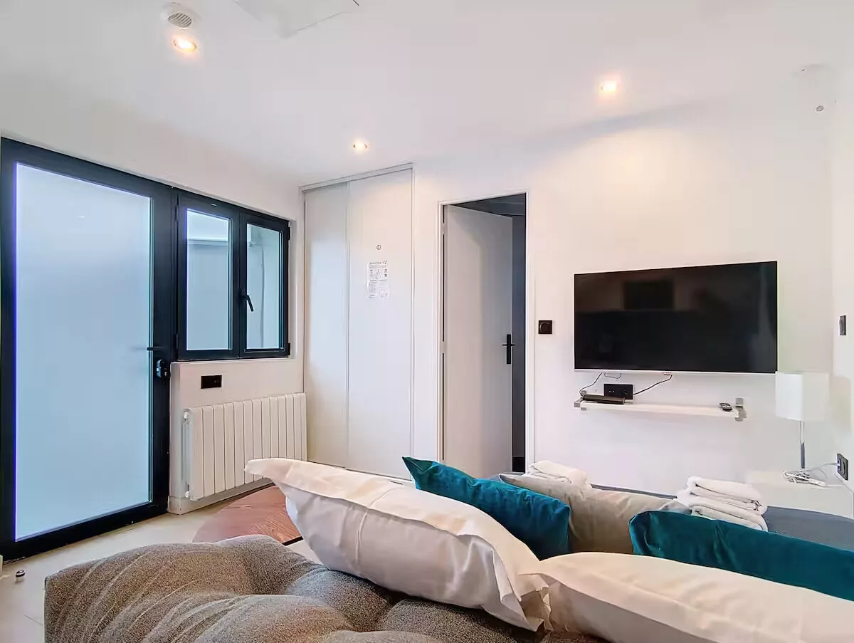 salon be happy argentueil Chambre moderne avec télévision et canapé.